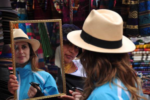 A Laura experimenta chapéu no mercado de Otavalo, no Equador